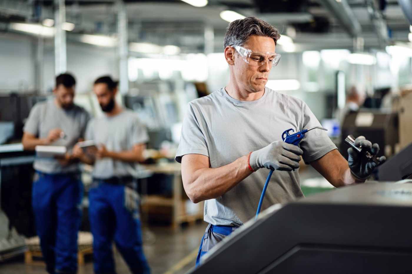 Intérieur d'un atelier industriel avec opérateur, illustrant une ligne de production sidérurgique
